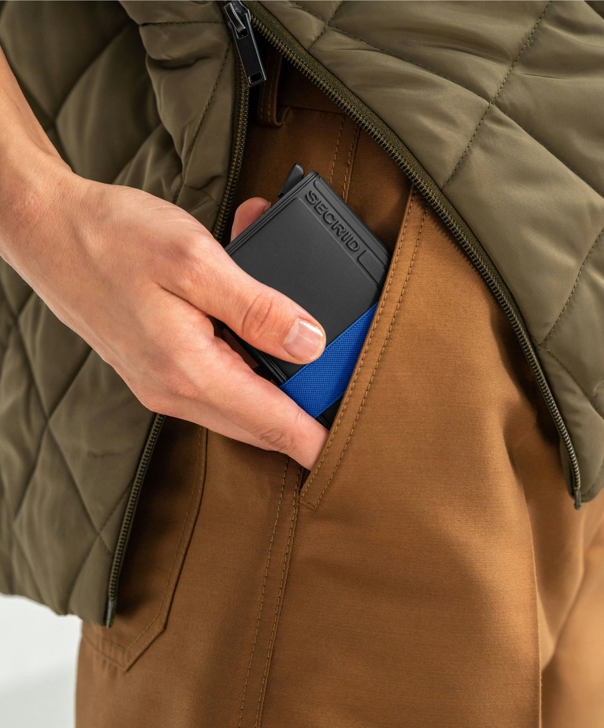 A guy holding his Secrid Bandwallet closest to his pants pocket